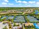 An aerial view showcasing community tennis courts surrounded by lush landscaping and picturesque lakes at 17916 Northwood Pl, Lakewood Ranch, FL 34202