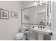 Cozy half bathroom featuring a pedestal sink, a large mirror, and decorative accents at 17916 Northwood Pl, Lakewood Ranch, FL 34202