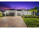 Elegant stucco home featuring a tile roof, three-car garage, and lush landscaping, offering curb appeal at 17916 Northwood Pl, Lakewood Ranch, FL 34202