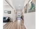 Inviting hallway with wood-look floors, decorative paintings, and easy access to the living room at 17916 Northwood Pl, Lakewood Ranch, FL 34202