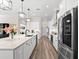 Bright kitchen with a center island, stainless appliances, quartz countertops, and wood-look flooring at 17916 Northwood Pl, Lakewood Ranch, FL 34202