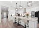 Bright kitchen features a center island with quartz countertops, bar seating, stainless appliances, and wood-look flooring at 17916 Northwood Pl, Lakewood Ranch, FL 34202
