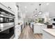 Spacious gourmet kitchen with stainless appliances, center island, quartz countertops, and an open layout to the living area at 17916 Northwood Pl, Lakewood Ranch, FL 34202