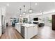 Open-concept kitchen features a center island with seating, stainless appliances, a dishwasher, and wood-look flooring at 17916 Northwood Pl, Lakewood Ranch, FL 34202
