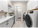Laundry room with white cabinets, countertop, washer, and dryer at 17916 Northwood Pl, Lakewood Ranch, FL 34202