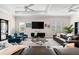 Well-lit living room with dual ceiling fans, a modern TV, and comfortable seating at 17916 Northwood Pl, Lakewood Ranch, FL 34202