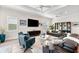 Contemporary living room with unique decor, large TV, and multiple seating arrangements at 17916 Northwood Pl, Lakewood Ranch, FL 34202