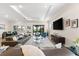Spacious living room featuring a tray ceiling, large TV, and plush seating area at 17916 Northwood Pl, Lakewood Ranch, FL 34202