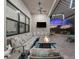 Covered outdoor patio with comfortable seating, television, and outdoor kitchen at 17916 Northwood Pl, Lakewood Ranch, FL 34202
