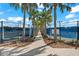 Tennis courts along a paved pathway lined with palm trees, manicured landscape, and blue fencing at 17916 Northwood Pl, Lakewood Ranch, FL 34202