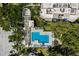 Aerial view of pool and spa with deck area and lush landscaping at Fairway Bay community at 1928 Harbourside Dr # 1403, Longboat Key, FL 34228