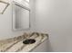 Elegant powder room with granite countertop and decorative mirror at 1928 Harbourside Dr # 1403, Longboat Key, FL 34228