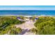 Scenic beach access with shaded picnic areas, lush greenery, and volleyball court surrounded by palm trees at 1928 Harbourside Dr # 1403, Longboat Key, FL 34228
