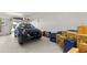 Spacious garage featuring a modern blue SUV, storage boxes, and open overhead door at 1928 Harbourside Dr # 1403, Longboat Key, FL 34228