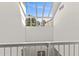 Bright hallway with natural light streaming through the large skylight and white railing at 1928 Harbourside Dr # 1403, Longboat Key, FL 34228