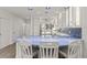 Bright kitchen features modern white cabinetry, blue backsplash, and breakfast bar seating at 1928 Harbourside Dr # 1403, Longboat Key, FL 34228