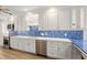 Gourmet kitchen featuring stainless steel appliances, custom white cabinets, and blue backsplash at 1928 Harbourside Dr # 1403, Longboat Key, FL 34228