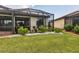 Lush backyard featuring a screened-in patio, perfect for outdoor enjoyment at 19993 Benissimo Dr, Venice, FL 34293