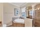 This bathroom features a soaking tub, a glass-enclosed shower, and window views at 19993 Benissimo Dr, Venice, FL 34293