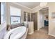 Bathroom with soaking tub, glass-enclosed shower, and natural light from a large window at 19993 Benissimo Dr, Venice, FL 34293