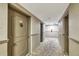 Hallway view features unit door, F104, with unique door knocker, fire extinguisher, and neutral colors at 2100 Benjamin Franklin Dr # 104, Sarasota, FL 34236