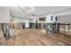 An unfinished living room shows an open layout with updated lighting and wood floors at 2100 Benjamin Franklin Dr # 104, Sarasota, FL 34236