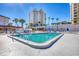 Community pool area with well-maintained pool, palm trees, and building in the background at 2100 Benjamin Franklin Dr # 104, Sarasota, FL 34236