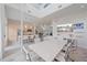 Bright dining area features a modern white table, an open floorplan with a kitchen and media center at 232 Cosmopolitan Ct, Sarasota, FL 34236