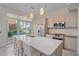 Bright kitchen boasts an island with bar seating, stainless steel appliances, and outdoor access at 232 Cosmopolitan Ct, Sarasota, FL 34236