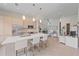 Modern open-concept kitchen features stainless steel appliances, an island, and access to the staircase at 232 Cosmopolitan Ct, Sarasota, FL 34236