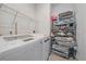 Laundry room equipped with modern washer, dryer and shelving unit at 232 Cosmopolitan Ct, Sarasota, FL 34236