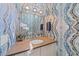 Stylish powder room with designer wallpaper, modern vanity, and elegant lighting fixtures at 232 Cosmopolitan Ct, Sarasota, FL 34236