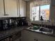 Efficient kitchen featuring granite countertops, stainless sink, and view of exterior greenery at 2330 Canal Dr # G27, Bradenton, FL 34207