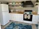 Bright kitchen featuring white cabinets, butcher block countertops, and open shelving at 2601 Gulf N Dr # 221, Bradenton Beach, FL 34217