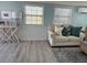 Cozy living room featuring a comfortable loveseat, stylish decor, and natural light from two windows at 2601 Gulf N Dr # 221, Bradenton Beach, FL 34217