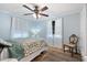 Bright bedroom with light blue walls and a ceiling fan, featuring a comfortable bed and natural light at 2728 Trinidad St, Sarasota, FL 34231