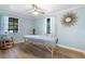 Relaxing bedroom featuring an adjustable massage table, wood laminate flooring, and natural light through bright windows at 2728 Trinidad St, Sarasota, FL 34231
