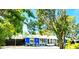 Charming blue home with stone accents and mature trees, offering curb appeal and a welcoming atmosphere at 2728 Trinidad St, Sarasota, FL 34231