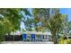 Charming blue home with stone accents and mature trees, offering curb appeal and a welcoming atmosphere at 2728 Trinidad St, Sarasota, FL 34231