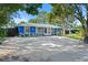 This blue home has stone accents and a large yard with mature trees, enhancing its charm and privacy at 2728 Trinidad St, Sarasota, FL 34231