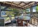 Inviting covered patio with a dark stained wood table and bar-height chairs, perfect for outdoor dining and relaxation at 2728 Trinidad St, Sarasota, FL 34231