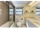 Bright bathroom featuring a glass shower, white cabinets, and a large mirror at 3111 Bayou Sound, Longboat Key, FL 34228