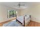 Bedroom with hardwood floors, ceiling fan, and a large window at 3111 Bayou Sound, Longboat Key, FL 34228