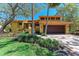 Charming yellow home with a tile roof, lush landscaping, and a brick driveway at 3111 Bayou Sound, Longboat Key, FL 34228