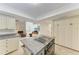 Open kitchen showcasing granite countertops, an island cooktop, and a view into the living room at 3111 Bayou Sound, Longboat Key, FL 34228
