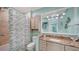 A bright bathroom with a granite countertop, decorative fish accents, and tiled shower/tub at 314 Bay S Dr # 5, Bradenton Beach, FL 34217