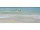 Serene beach view showcasing clear water and soft waves gently meeting the sandy shore at 314 Bay S Dr # 5, Bradenton Beach, FL 34217