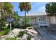 Charming Island Playhouse exterior featuring a quaint porch and lush tropical landscaping at 314 Bay S Dr # 5, Bradenton Beach, FL 34217
