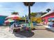 Outdoor courtyard adorned with colorful chairs, tables, umbrellas, and tropical plants at 314 Bay S Dr # 5, Bradenton Beach, FL 34217