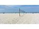Volleyball net on a sandy beach near blue waters and relaxing people at 314 Bay S Dr # 5, Bradenton Beach, FL 34217